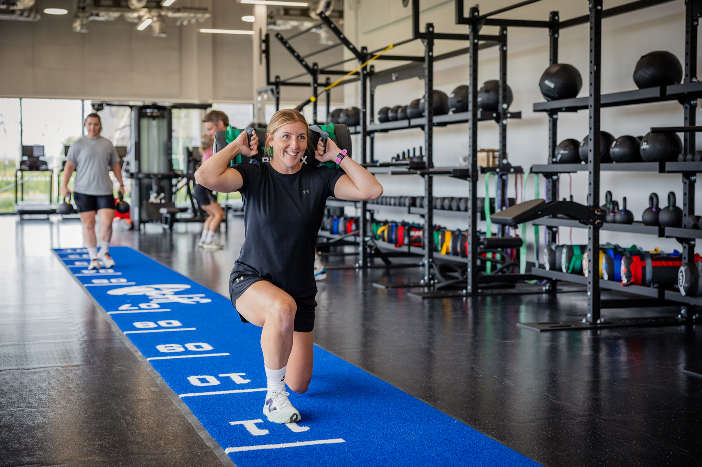Lady carrying a sandbag over her shoulders