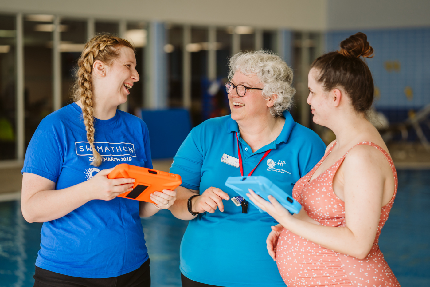 swimming instructor laughing with 2 mums
